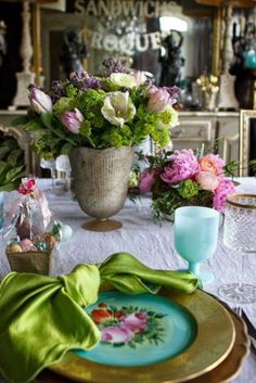 the table is set with flowers and plates