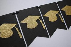 four black and gold graduation decorations on a wall