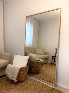 a mirror sitting on top of a wooden floor next to a couch