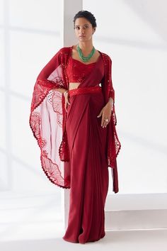 Red pre-draped plain saree crafted in crepe. Paired with a cape sleeves yemeni bloom embroidered cape using tonal thread, sequins, beads, mirror highlights, embellished padded blouse and hand embroidered belt. - Aza Fashions Elegant Red Pre-draped Saree For Festive Occasions, Elegant Red Pre-draped Saree For Diwali, Red Fitted Pre-draped Saree For Wedding, Elegant Red Pre-draped Saree With Sheer Dupatta, Red Pre-draped Saree With Sheer Dupatta For Evening, Red Fitted Pre-draped Saree With Zari Work, Red Pre-draped Saree For Party, Fitted Red Pre-draped Saree With Sheer Dupatta, Red Georgette Saree For Formal Occasions