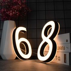 the number eight is lit up in front of a wall