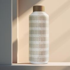 a white vase sitting on top of a shelf next to a window sill with sunlight streaming through it