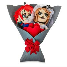 two dolls in a bouquet with red hearts