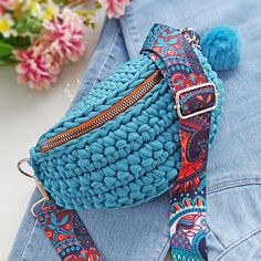 a blue purse sitting on top of a denim jacket