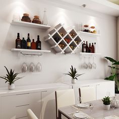 a dining room table with wine glasses and bottles on the wall