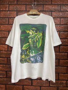 Vintage 90s Conart 1991 Hip Hop Streetwear Brand Rap T Shirt / Hip Hop 90s / Raptee / Raptees / Vintage Hip Hop T Shirt Made In Usa Size XL Condition : Good Used  Size on tag : XL Colour : White Brand : Conart Measurement : Armpit to armpit - 23" Length - 28" Material : Cotton Made In: USA  THE SHIPPING (Your Choice Please read) 1. The shipping cost is USD 20 via Malaysian Registered Postage With Tracking Number. It will take 2-4 weeks or more for delivery, depends on your custom checking. 2. Ad Pop Culture Green Tops For Streetwear, 90s Style Green T-shirt For Streetwear, Green Retro T-shirt For Streetwear, Retro Green T-shirt For Streetwear, 90s Style Relaxed Fit Graffiti T-shirt, Hip Hop Graphic Crew Neck Shirt, 90s Green T-shirt For Streetwear, Hip Hop Graphic Print Crew Neck Shirt, Hip Hop Crew Neck T-shirt