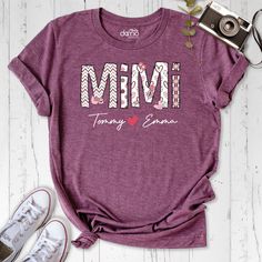 Elevate your grandmother style with our Mimi Shirt, a personalized and heartwarming tribute to the joys of grandmotherhood. This Custom Grandkids Name Tshirt is more than just apparel; It's a celebration of the unique bond you share with your beloved grandchildren. The Personalized Grandmother Heart Print Outfit is a custom-designed masterpiece, featuring the names of your grandchildren intertwined with a heart, symbolizing the love that connects generations. Whether you're looking for the perfe Personalized T-shirt For Anniversary And Mother's Day, Personalized Casual Tops For Anniversary, Casual Personalized Tops For Anniversary, Personalized Short Sleeve Tops For Anniversary, Crew Neck T-shirt For Mother's Day Anniversary, Personalized Cotton Tops For Anniversary, Personalized T-shirt For Family Reunion On Mother's Day, Mother's Day Cotton T-shirt, Mother's Day Anniversary Cotton T-shirt