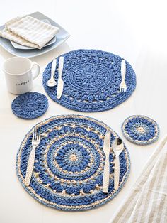 blue placemats, plates and utensils on a white table