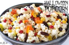 a bowl filled with halloween popcorn and candy