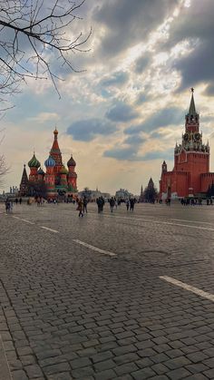 people are walking around in front of the red square and kreme tower, moscow