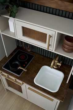 a stove top oven sitting inside of a kitchen next to a wooden counter with white cabinets