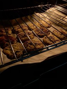 cookies baking in an oven on top of parchment paper and cooling rack with light coming through