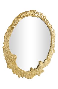 a mirror that is sitting on top of a white surface and gold leafy decoration