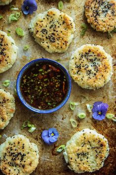 some food that is on a table with blue flowers and sauce in a bowl next to it