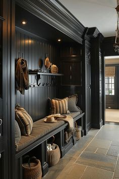 a hallway with black wood paneling and lots of pillows on the bench next to it