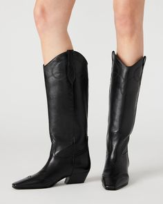 The DOLLIE Western boot offers a sleek and stylish design with a square toe. Experience comfort and durability with every step. Elevate your wardrobe with this timeless and versatile statement piece. 1.75 inch heel height Size 6 measurements: 15 inch shaft circumference, 13 inch shaft height Size 8 measurements: 16 inch shaft circumference, 14 inch shaft height Size 10 measurements: 17 inch shaft circumference, 14.75 inch shaft height Leather upper material Textile and synthetic lining Synthetic Black Cowboy Boots, Black Cowboy, Leather Western Boots, Western Boots Women, Leather Wear, Cowboy Boots Women, Western Boot, Black Leather Boots, Gold Leather