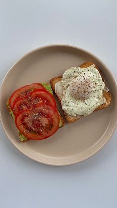 an egg and tomato sandwich is on a plate