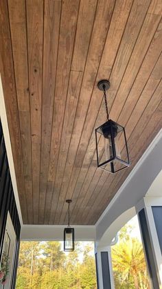 a porch with wood planks and lanterns hanging from the ceiling