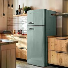 a green refrigerator sitting in the middle of a kitchen