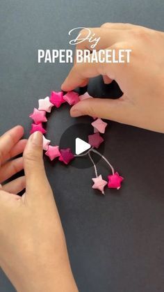 someone is making some pink stars out of paper