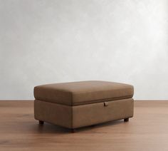 a brown ottoman sitting on top of a wooden floor