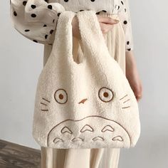 Introducing our My Neighbor Totoro Tote Bag – the epitome of softness and adorableness! Totoro's friendly face is skillfully embroidered on the front, ready to accompany you on your daily adventures. This compact tote is designed to carry your essentials with ease, making it the perfect companion for outings with friends. Available in both white and brown, you can choose the hue that suits your style. Whether you're strolling through the city or meeting up with pals, let Totoro's charm and your Totoro Tote Bag, Totoro Bag, Fabric Handbags, Plush Bags, Handbag Outfit, Cat Tote, Fabric Purses, My Neighbor Totoro, Tote Pattern