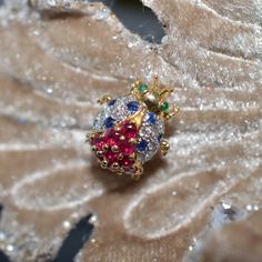 A Ladies 18K Yellow Gold Lucky Ladybug Pin By LeVian Set With 12 Round Diamonds Having A Total Approximate Weight Of .18 Carats, 10 - 2.5 Mm Round Rubies, 8 - 1.7 Mm Round Sapphires, And 2 - 1.3 Mm Round Cabochon Emerald Eyes. The Pin Measures 5/8 Inch In Length And Can Also Be Worn As A Pendant. This LeVian Pin Is Circa 1980 And Has Inventory Number 1270. Lucky Ladybug, Vintage Jewelry Antique, Emerald Eyes, Round Sapphire, Jewelry Antique, Mens Accessories Fashion, Treasure Chest, Estate Jewelry, Citrine