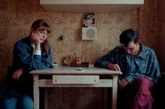 two people sitting at a table in a room