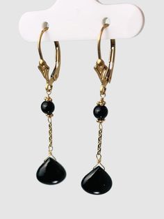 Onyx 2 station drop earrings. Earrings contain a pair of 9.8mm wide smooth onyx drops hang from yellow gold chain with a pair of 4.1mm round beads on 14k yellow gold lever backs. Earrings are 1.8" long. Metal - 14k Yellow Gold Gemstones - Onyx Length - 1.8" 14k Gold Pierced Jewelry For Evening, Yellow Gold Dangle Jewelry For Evening, Yellow Gold Long Drop Evening Jewelry, Black Teardrop Fine Jewelry Earrings, Elegant Black 14k Gold Jewelry, Formal Long Drop Pierced Jewelry, 14k Gold Linear Earrings For Evening, Elegant Drop Earrings With Lever Back, 14k Gold Briolette Pierced Jewelry