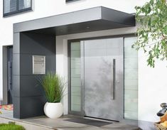 an entrance to a modern home with glass doors