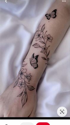 a woman's arm with flowers and butterflies on it