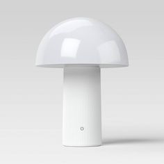 the mushroom lamp is white and has a light on it