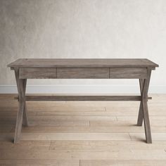 a wooden table sitting on top of a hard wood floor next to a white wall