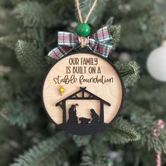 a christmas ornament hanging on a tree with the words our family is built on a stable foundation