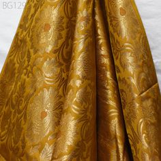 Peanut Butter Indian Wedding Dress Material Fabric By The Yard Silk Banarasi Brocade Home Decor Table Runner Cushion Covers Crafting Sewing. This is a beautiful benarse silk brocade floral design fabric in Brown and Gold. The fabric illustrate golden woven beautiful design on Peanut Butter Brown and Gold Fabric. ➤Listing for 1 Yard of fabric.  ➤Width of the fabric is 44 inches. ➤Code:-bg1292 ➤Color: Peanut Butter Brown and Gold Fabric Type: Blended Silk (Viscose and Silk) Super Fine Quality Brocade Weaving from Banaras, which is known as "Kimkhab". During the Mughal period (1556-1707), when kimkhwāb was extremely popular with the rich, the great centres of brocade weaving were Benares (Vārānasi). You can use this fabric to make Dresses, Tops, Blouses, Jackets, Crafting, Clutches or Evening Luxury Gold Banarasi Silk Dupatta, Luxury Bollywood Gold Embroidered Fabric, Wedding Dress Material, Banarasi Brocade, Home Decor Table, Party Wear Indian Dresses, Silk Brocade, Decor Table, Gold Fabric