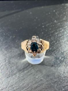 A very stately vintage 9ct yellow gold sapphire and diamond cluster ring featuring a dark blue oval cut sapphire stone prong set on a raised setting surrounded by a halo of small sparkling eight round cut illusion set diamonds leading to a wide flat tapering shoulders with decorative texture and a plain band. Decorative Texture, Vintage Sapphire, Dress Ring, Plain Bands, Dress Rings, Sapphire Stone, Diamond Cluster Ring, Multi Stone Ring, Ring Engagement