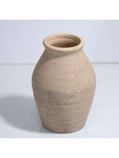 a large brown vase sitting on top of a white table