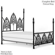 an iron bed frame with white sheets and black posts on the headboard is shown