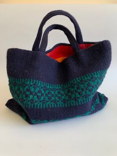 "This is a beautiful tribal handwoven handbag, made of wool yarn and cotton lining. This bohemian purse is navy blue color with a hint of green. It has two handles and open top. The interior is lined in red checkered cotton fabric. This woven wool purse has one compartment and one slip pocket. Era: 90s Condition: This woven handbag is beautifully preserved. It does have some minor flaws, due to the texture of the wool fabric - it has caught some fine fibers and tiny straws, which I have tried to Everyday Weaving Work Shoulder Bag, Everyday Shoulder Bag With Weaving Work, Blue Rectangular Bags For Festival, Blue Handwoven Festival Bag, Blue Bohemian Bags With Handles, Rectangular Travel Bag With Weaving Work, Bohemian Green Crochet Bag With Large Capacity, Square Woven Bag For Everyday Use, Woven Travel Tote Bag