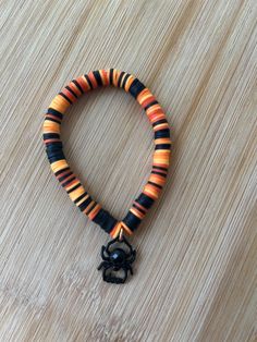 an orange and black beaded bracelet on a wooden surface