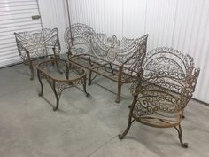 four wrought iron chairs sitting next to each other in front of a white garage door