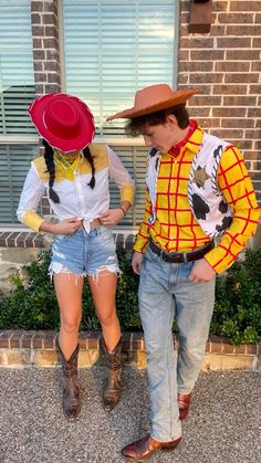 two people wearing cowboy hats standing next to each other