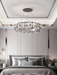 a bedroom with a large bed and a chandelier hanging above the headboard