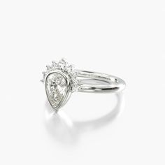 a white gold and diamond ring with an open pear shaped design on the side, set in