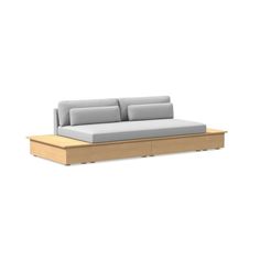 a couch that is sitting on top of a wooden platform with two pillows in it