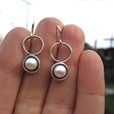 A minimal and modern look with a nod to old school pearl earrings. These sterling silver and pearl earrings are set in a modern round shadow bezel style and hang from sculptural open circles. The cultured pearl is half drilled on the bottom and glued to a sterling post soldered to the necklace for durability. You will get a lot of compliments when wearing this mini art piece.To see all my pearl jewelry go here:https://www.etsy.com/shop/marmarModern?ref=seller-platform-mcnav&section_id=132837 Modern Hypoallergenic Pearl Earrings For Everyday, Modern Pearl Earrings With Ear Wire For Everyday, Modern Round Pearl Earrings, Everyday Sterling Silver Pearl Earrings, Modern Dangle Pearl Earrings For Everyday, Modern Everyday Dangle Pearl Earrings, Modern Sterling Silver Pearl Earrings For Gift, Modern Round Sterling Silver Pearl Earrings, Modern Sterling Silver Pearl Earrings As Gift