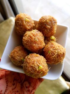 a white bowl filled with food sitting on top of a table next to a window