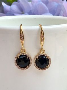 Lightweight and easy to wear, these dainty earrings are also elegant and classic. The bezel set 8mm faceted round onyx gemstones are surrounded by sparkly cz's set in gold bezels and suspended from equally sparkly gold ear wires that have cz's set in them as well. All jewelry is sent to you packaged in a gift box that is tied off with ribbon and a charm, ready for gift giving. Luxury Onyx Earrings For Formal Occasions, Elegant Black Round Cut Earrings, Gold Earrings With Halo Setting, Elegant Gold Earrings With Halo Setting, Gold Dangle Earrings With Bezel Setting, Gold Bezel-set Dangle Earrings, Gold Faceted Earrings For Evening, Elegant Gold Earrings With Bezel Setting, Elegant Faceted Earrings For Party