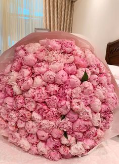 a large bouquet of pink peonies on a table