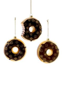 three brown and white donuts hanging from strings on a white background, one is decorated with chocolate icing